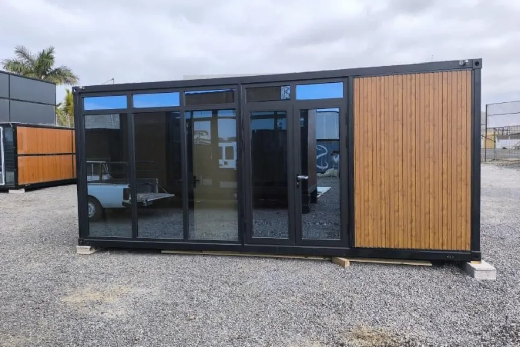 Módulo de oficina en madera y negro con grandes puertas de cristal